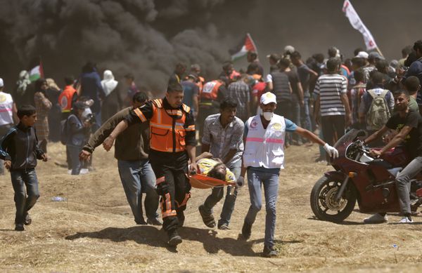 Palestinians carry a demonstrator injured during clashes with Israeli forces near the border between the Gaza strip and Israel east of Gaza City on May 14, 2018, as Palestinians readied for protests over the inauguration of the US embassy following its controversial move to Jerusalem Palestinians carry a demonstrator injured during clashes with Israeli forces near the border between the Gaza strip and Israel east of Gaza City on May 14, 2018, as Palestinians readied for protests over the inauguration of the US embassy following its controversial move to Jerusalem - Sputnik International