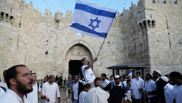 Israelis celebrate as they hold an Israeli flag during a parade marking the annual Jerusalem Day, outside Damascus Gate of Jerusalem's Old City, May 13, 2018 Israelis celebrate as they hold an Israeli flag during a parade marking the annual Jerusalem Day, outside Damascus Gate of Jerusalem's Old City, May 13, 2018 - Sputnik International