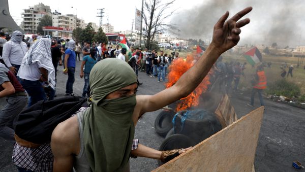 A Palestinian demonstrator gestures during a protest marking the 70th anniversary of Nakba, near the Jewish settlement of Beit El, near Ramallah, in the occupied West Bank May 15, 2018 - Sputnik International