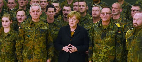 German chancellor Angela Merkel (C) poses next to Surgeon General Michael Tempel (L) and commander Dirk Moellmann (2L) and members of the German army Rapid Medical Response Forces Command in Leer, northern Germany, on December 7, 2015 - Sputnik International