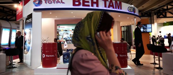A South Korean businesswoman speaks on her mobile phone in front of the stand of French oil and gas company Total, at Iran's annual International Oil, Gas, Refining & Petrochemical Exhibition in Tehran, on May 6, 2014 A South Korean businesswoman speaks on her mobile phone in front of the stand of French oil and gas company Total, at Iran's annual International Oil, Gas, Refining & Petrochemical Exhibition in Tehran, on May 6, 2014 - Sputnik International