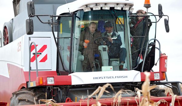 Vladimir Putin (left) seen inside the grain harvester while being briefed on progress in the corn harvesting campaign at the Rodina farm, Shpakovsky district, October 25, 2011 - Sputnik International