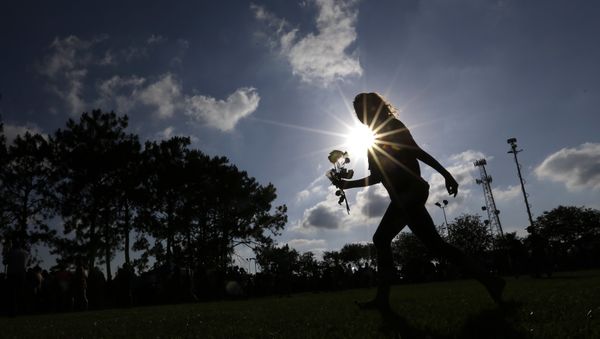 Hannah Harrison carries roses during a prayer vigil following a deadly shooting at Santa Fe High School in Santa Fe, Texas, on Friday, May 18, 2018 - Sputnik International