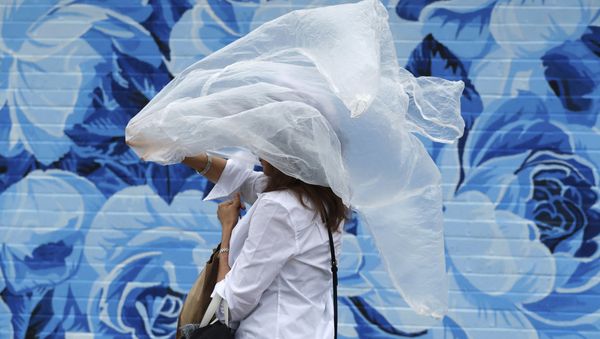 A woman puts on a plastic cover before the 144th running of the Kentucky Derby horse race - Sputnik International
