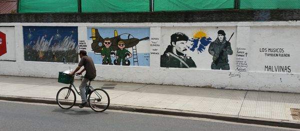 A man cycles past a mural about the Malvinas War on the wall of a military base in Buenos Aires - Sputnik International