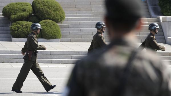 In this April 18, 2018 photo, North Korean soldiers march as a South Korean soldier, center, stands guard during a press tour at the border village of Panmunjom in the Demilitarized Zone, South Korea - Sputnik International