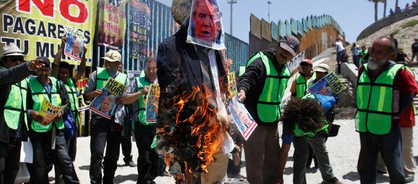 Demonstrators burn an effigy depicting U.S. President Donald Trump during a protest against the immigration policies of Trump's government near the border fence between Mexico and the U.S., in Tijuana, Mexico May 10, 2018 Demonstrators burn an effigy depicting U.S. President Donald Trump during a protest against the immigration policies of Trump's government near the border fence between Mexico and the U.S., in Tijuana, Mexico May 10, 2018 - Sputnik International
