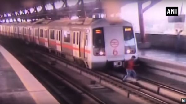 Watch video: Man crosses tracks at Delhi Metro station as train starts moving - Sputnik International