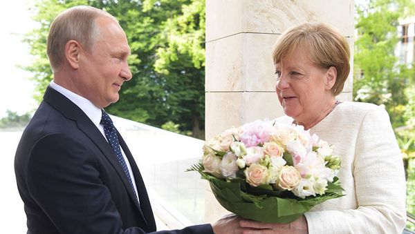 Putin gives Chancellor Merkel flowers, May 21, 2018 - Sputnik International
