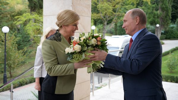 President Putin giving Croatian President Kolinda Grabar-Kitarovic a bouquet during her visit to Russia, October 2017. - Sputnik International