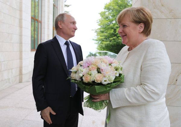 German Chancellor Angela Merkel with bouquet from Vladimir Putin German Chancellor Angela Merkel with bouquet from Vladimir Putin - Sputnik International