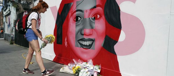 A woman places flowers by a mural showing Savita Halappanavar, a 31-year-old Indian dentist who had sought and been denied an abortion before she died after a miscarriage in a Galway hospital, with the word YES over it, in Dublin, Ireland, on the day of a referendum on the 8th amendment of the constitution. A woman places flowers by a mural showing Savita Halappanavar, a 31-year-old Indian dentist who had sought and been denied an abortion before she died after a miscarriage in a Galway hospital, with the word YES over it, in Dublin, Ireland, on the day of a referendum on the 8th amendment of the constitution. - Sputnik International