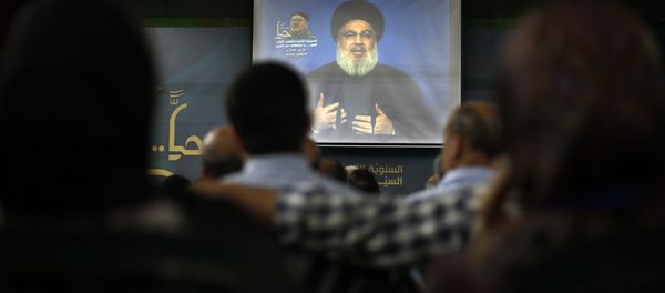 Hezbollah leader Sheik Hassan Nasrallah speaks on a screen via a video link during a ceremony to mark the second anniversary of the death of Hezbollah top commander, Mustafa Badreddine, who was killed in an explosion in Damascus, in the southern suburbs of Beirut, Lebanon, Monday, May 14, 2018 - Sputnik International