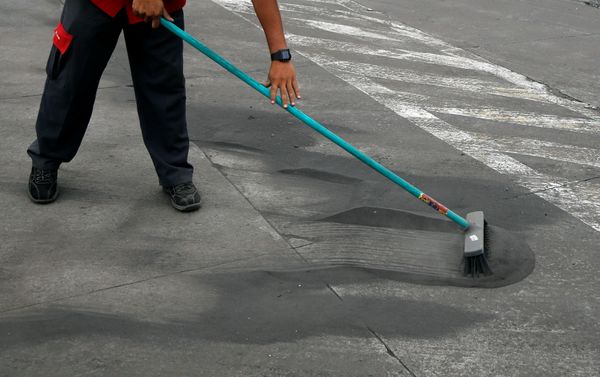 An employee sweeps the entrance of a gas station covered with ash after Guatemala's Fuego volcano erupted violently, in Guatemala City, Guatemala June 3, 2018. - Sputnik International