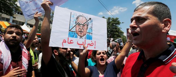 A Jordanian protester holds a picture of Jordanian Prime Ministers Hani al-Mulki and chants slogans during a strike against the new income tax law, in Amman, Jordan May 30, 2018 - Sputnik International