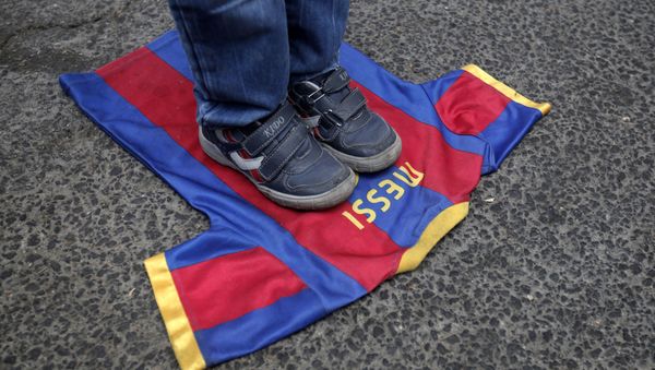 (FILES) In this file photo taken on October 07, 2012, a Palestinian boy steps on a T-shirt of Spanish FC Barcelona football club with the name of it's Argentinian player, Lionel Messi, during a demonstration outside the Spanish consulate in eastern Jerusalem on October 7, 2012 to protest against Barcelona's invitation of Israeli slodier Gilad Shalit to attend today's El Clasico match - Sputnik International