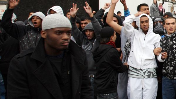 British man Michael Adebolajo (L) walks by a line of local people linking arms in reaction to a planned demonstration by members of the English Defence League (EDL) near Harrow Mosque in London on September 11, 2009 - Sputnik International