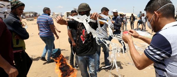 Palestinian demonstrators prepare to set a kite on fire to be thrown at the Israeli side during a protest demanding the right to return to their homeland, at the Israel-Gaza border in the southern Gaza Strip, May 11, 2018 Palestinian demonstrators prepare to set a kite on fire to be thrown at the Israeli side during a protest demanding the right to return to their homeland, at the Israel-Gaza border in the southern Gaza Strip, May 11, 2018 - Sputnik International