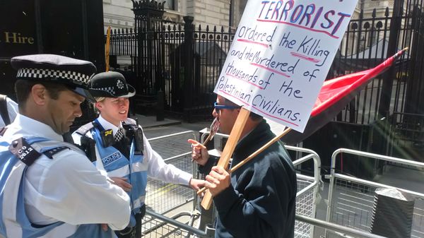 A protester demonstrates with police outside Downing Street A protester demonstrates with police outside Downing Street - Sputnik International