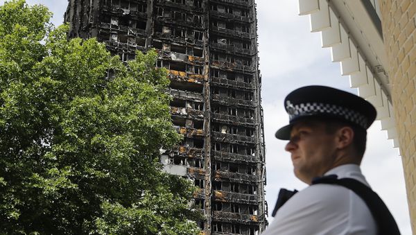 A police officer stands near to the burnt Grenfell Tower apartment building standing testament to the recent fire in London, Friday, June 23, 2017.  - Sputnik International