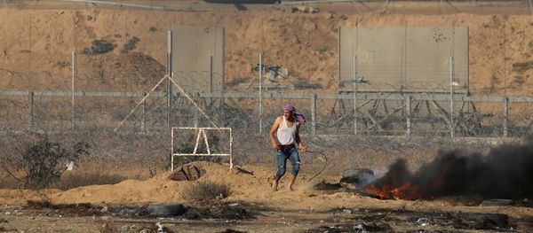 A Palestinian demonstrator stands next to the Israeli fence during a protest marking Naksa, at the Israel-Gaza border in the southern Gaza Strip June 5, 2018 - Sputnik International