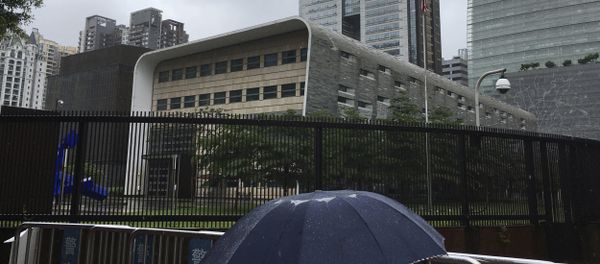 A man carries an umbrella past the U.S. consulate building in Guangzhou in south China's Guangdong province, Thursday, June 7, 2018 - Sputnik International