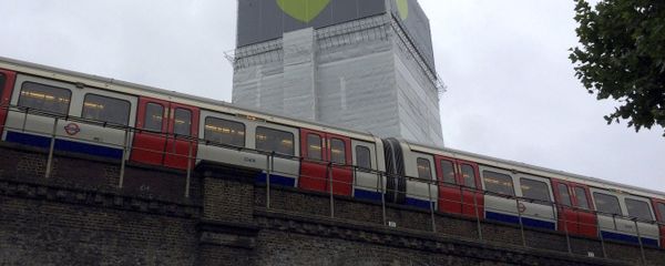 A London Underground train comes to a halt next to Grenfell Tower as a minute's silence is marked on June 14, 2018 - Sputnik International