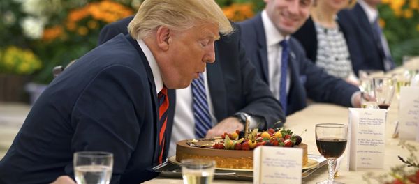 In this photo released by the Ministry of Communications and Information of Singapore, U.S. President Donald Trump blows out a candle on a cake celebrating an early birthday during lunch with Singapore's Prime Minister Lee Hsien Loong in Singapore, Monday, June 11, 2018 - Sputnik International
