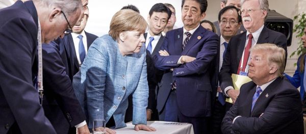 German Chancellor Angela Merkel, center, speaks with US President Donald Trump, seated at right, during the G7 Leaders Summit in La Malbaie, Quebec, Canada, 9 June, 2018 - Sputnik International