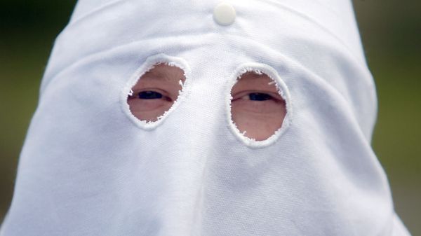 An unidentified member of the Ku Klux Klan peers from beneath a hooded mask at a Ku Klux Klan rally Saturday, June 10, 2006 - Sputnik International