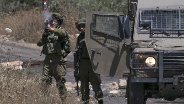 Israeli soldiers take position as Palestinian protesters clash with Israeli forces during a weekly demonstration against the expropriation of Palestinian land by Israel in the village of Kfar Qaddum, near Nablus in the occupied West Bank on May 18, 2018 - Sputnik International