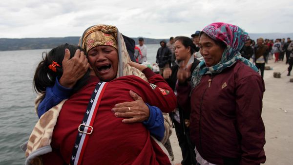 Relatives cry while waiting for news on missing family members who were on a ferry that sank yesterday in Lake Toba, at Tigaras Port, Simalungun, North Sumatra, Indonesia June 19, 2018 - Sputnik International