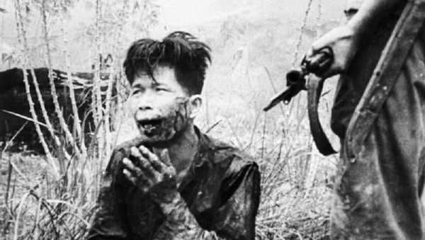 A wounded terrorist being held at gunpoint after his capture, in Malaya - Sputnik International