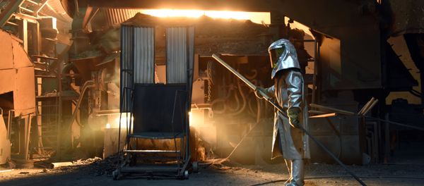 A steelworker in a protective suit checks the temperature of molten metal in furnace at the TMK Ipsco Koppel plant in Koppel, Pennsylvania on March 9, 2018 - Sputnik International