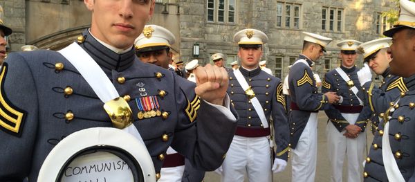 In this May 2016 photo provided by Spenser Rapone, Rapone raises his left fist while displaying a sign inside his hat that reads Communism will win, after graduating from the United States Military Academy at West Point, N.Y. - Sputnik International