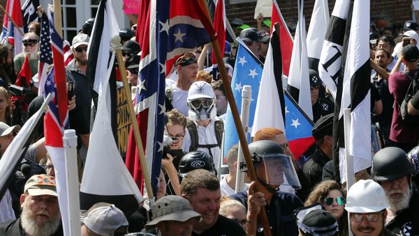 In this Saturday, Aug. 12, 2017, file photo, white nationalist demonstrators walk into the entrance of Lee Park surrounded by counter demonstrators in Charlottesville, Va. - Sputnik International