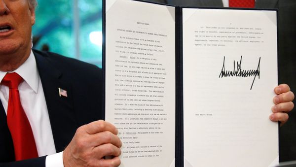 U.S. President Donald Trump displays an executive order on immigration policy after signing it in the Oval Office at the White House in Washington, U.S., June 20, 2018. - Sputnik International