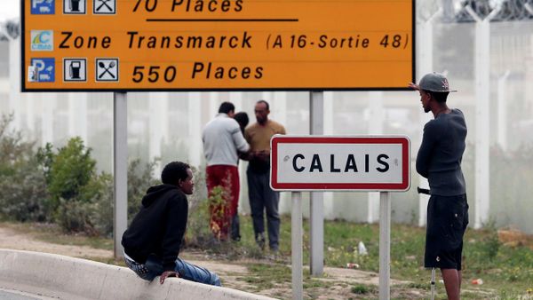 Migrants stand near a city sign along a road near the makeshift camp called The New Jungle in Calais - Sputnik International