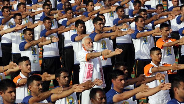 Indian Prime Minister Narendra Modi, center, performs yoga along with thousands of Indians to mark International Day of Yoga in Dehradun, India, Thursday, June 21, 2018 - Sputnik International