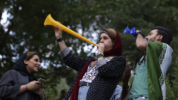 Iranian fans blow horns while watching the national soccer team play against Morocco in the 2018 World Cup, on a giant screen in a park in Tehran, Iran, Friday, June 15, 2018 - Sputnik International