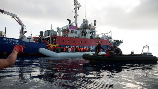 Migrants are seen in a rubber dinghy as they are rescued by the crew of the Mission Lifeline rescue boat in the central Mediterranean Sea, June 21, 2018 - Sputnik International