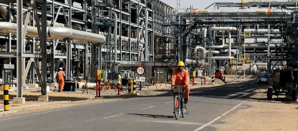 In this photograph taken on December 11, 2015, a worker cycles by machinery at Cairn India, Oil and Gas exploration plant at Barmer in Rajasthan - Sputnik International