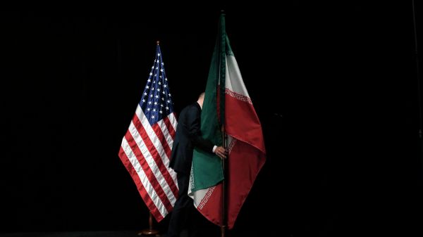 A staff member removes the Iranian flag from the stage after a group picture with foreign ministers and representatives of Unites States, Iran etc. A staff member removes the Iranian flag from the stage after a group picture with foreign ministers and representatives of Unites States, Iran etc. - Sputnik International