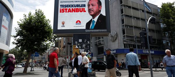 People walk past a poster for Turkey's President Tayyip Erdogan in Istanbul, Turkey, June 25, 2018. The poster reads: Our people won, Turkey won, Thank you istanbul - Sputnik International