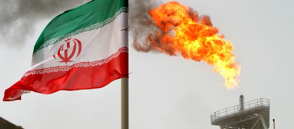 A gas flare on an oil production platform in the Soroush oil fields is seen alongside an Iranian flag in the Persian Gulf, Iran, July 25, 2005 - Sputnik International