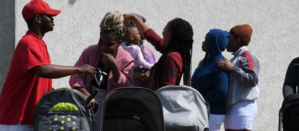 Residents of the Bavarian transit center (Bayerisches Transitzentrum) for asylum seekers stand in front of an apartment building in Manching, near Ingolstadt, southern Germany, on May 15, 2018 - Sputnik International