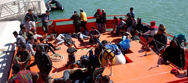 Migrants of a group intercepted aboard dinghies off the coast in the Strait of Gibraltar, are seen on a rescue boat after arriving at the port of Barbate, southern Spain, June 27, 2018 - Sputnik International