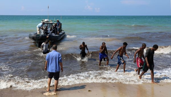 Migrants leave a boat at the coast of Tajoura, east of Tripoli, Libya June 20, 2018 - Sputnik International