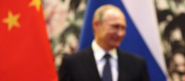 The Russian and Chinese national flags are seen on the table as Russia's President Vladimir Putin (back L) and his China's President Xi Jinping (back R) stand during a signing ceremony at the Diaoyutai State Guesthouse in Beijing on November 9, 2014. - Sputnik International
