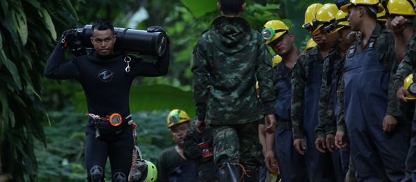 A diver carries an oxygen tank as he leaves the Tham Luang cave complex, where 12 boys and their soccer coach are trapped, in the northern province of Chiang Rai, Thailand, July 6, 2018 - Sputnik International